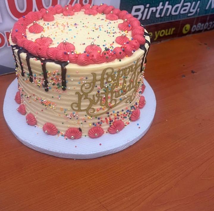 Buttercream birthday cake with pink piping and sprinkles
