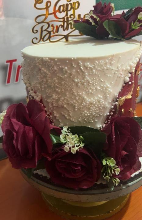 White cake with pearl detail and burgundy roses